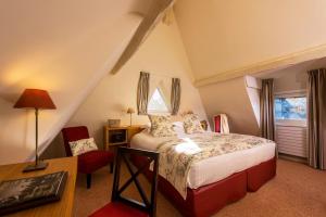 um quarto com uma cama, uma secretária e uma cadeira em Les Manoirs de Tourgéville em Deauville