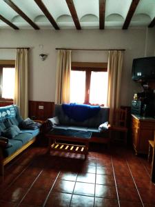a living room with a couch and a table at Casa Rural Lahuerta Apartamentos GUADALAVIAR in Guadalaviar