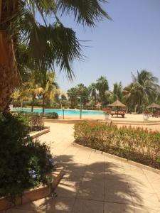 un complejo con piscina y palmeras en appartementsurlaplage, en Saly Portudal