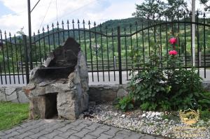 a stone fireplace in front of a fence at "Nad Zdrojami" Domek Sopotnicka 691-739-603 in Szczawnica
