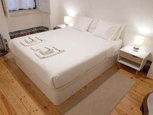 un letto bianco con lenzuola e cuscini bianchi di Stay at Home in Lisbon a Lisbona