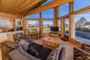 una sala de estar con sofás y TV en una cabaña en Lorien Lodge, en Breakish