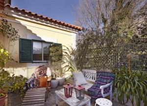 a patio with two chairs and a table in front of a house at At Home Sintra in Sintra