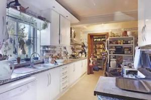 a large kitchen with white cabinets and a sink at At Home Sintra in Sintra