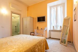 1 dormitorio con 1 cama y TV en la pared en Merulana Suite 2 en Roma