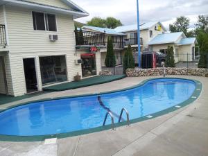 a large blue swimming pool in front of a house at Cache Creek Inn in Cache Creek