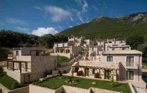 un grupo de casas blancas con montañas en el fondo en Hotel Tesoro en Nikiana