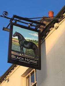 un panneau de cheval noir sur le côté d'un bâtiment dans l'établissement Black Horse, à Amberley