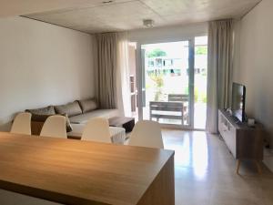 a living room with a couch and chairs and a television at Open Pinamar Resort in Pinamar