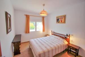 ein Schlafzimmer mit einem Bett und einem Fenster in der Unterkunft Mabruka - charming, Finca style holiday villa in Benissa in Benissa + 14 Fotos