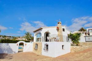 ein weißes Haus mit einem Balkon am Strand in der Unterkunft Mabruka - charming, Finca style holiday villa in Benissa in Benissa