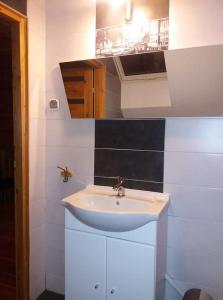 a bathroom with a white sink and black tiles at Agroturystyka Rogoznia in Rogóżnia +44 photos
