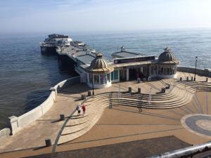 a pier with a building on the water at The Upper Bakery in Cromer