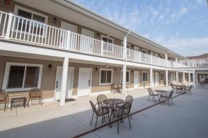 een terras met tafels en stoelen voor een gebouw bij Affordable Suites of America Portage in Portage