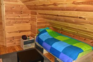 a bedroom with a bed in a wooden wall at Agroturystyka Rogoznia in Rogóżnia
