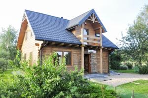 a log home with a blue roof at Agroturystyka Rogoznia in Rogóżnia