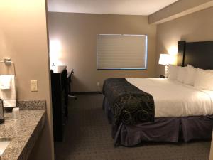 a hotel room with a bed and a bathroom at Okoboji Inn & Suites in Milford