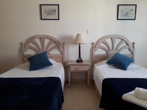 two beds with blue pillows in a room at Dunas do Alvor apartment 146 in Alvor