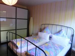 Schlafzimmer mit einem Bett mit Metallrahmen und Kissen in der Unterkunft Holiday Home Scheuerberg in Oberthal