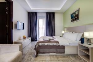 pokój hotelowy z łóżkiem i kanapą w obiekcie Riva Residence w mieście Herceg Novi