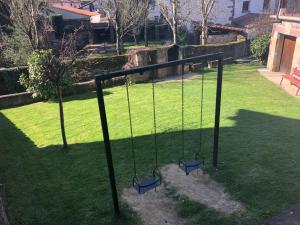 a swing set in a yard with green grass at Martintzenea in Sumbilla