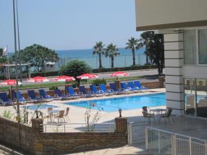 a swimming pool with chairs and umbrellas at Olbia Residence Hotel in Antalya