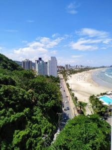 a view of a beach and the ocean with buildings at Apartamento frente para o Mar ,50 m da praia , ar condicionado todos quartos in Guarujá