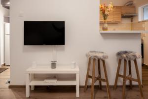 uma sala de estar com dois bancos e uma televisão em International Aparthotel em Cluj-Napoca