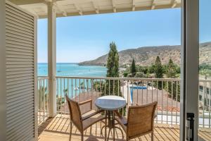 a balcony with a table and chairs and a view of the ocean at Columbia Beach Resort in Pissouri