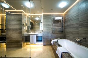 a bathroom with a tub and a sink at Columbia Beach Resort in Pissouri