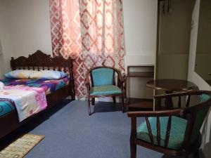Madid's Inn Beach Resort في بوراكاي: غرفة نوم بسريرين وطاولة وكراسي