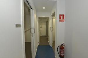 un pasillo con un extintor de incendios en una habitación en Hostel Albergue Baionamar, en Baiona