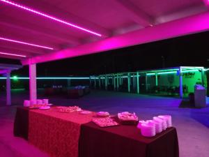 a room with a table with pink lights on it at Motel Kratos in Bisignano