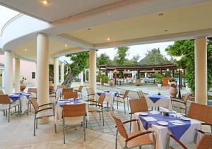 ein Restaurant mit blauen und weißen Tischen und Stühlen in der Unterkunft SENTIDO Apollo Palace in Mesongi