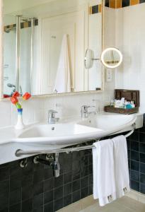 a bathroom with a sink and a mirror and towels at Columbia Beach Resort in Pissouri