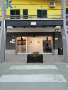 a store front with a yellow building at Motel Kratos in Bisignano