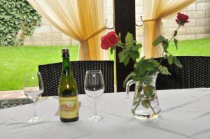 a bottle of wine and two glasses on a table at Pensiunea Normandia in Timişoara