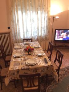 stół jadalny z talerzami i telewizor w obiekcie Gene Holiday Home w Rawennie