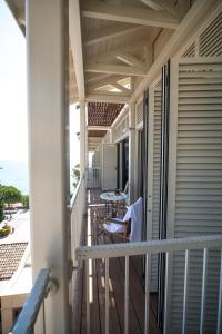 a balcony with chairs and tables on a house at Columbia Beach Resort in Pissouri