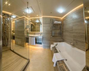 a bathroom with a tub and a shower and a sink at Columbia Beach Resort in Pissouri