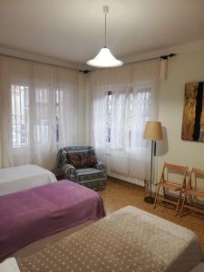 sypialnia z 2 łóżkami, krzesłem i lampką w obiekcie Ortensia - Sanremo Apartments w San Remo