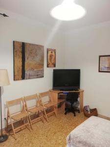 Pokój z dwoma krzesłami i telewizorem na stole w obiekcie Ortensia - Sanremo Apartments w San Remo