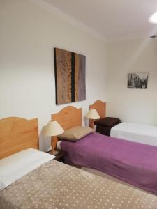 2 łóżka w pokoju z fioletową pościelą w obiekcie Ortensia - Sanremo Apartments w San Remo