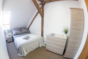 a bedroom with a bed and a dresser and a mirror at Fitness Hostel - restauracja, darmowy parking i siłownia in Wrocław