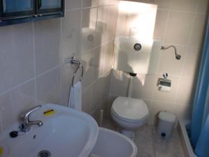 a bathroom with a white toilet and a sink at Casa Feijao - Alojamento Local in Geres +47 photos