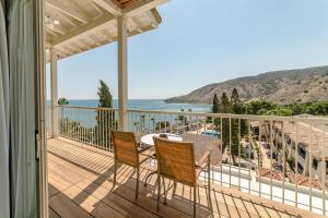 a balcony with a table and chairs and the ocean at Columbia Beach Resort in Pissouri