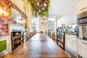 a kitchen with a long wooden table and chairs at The Wonderland Townhouse - Alice in Wonderland 7BDR Home in Bath