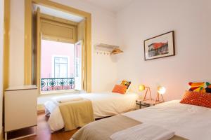 sypialnia z 2 łóżkami i oknem w obiekcie Coliseu by Central Hill Apartments w Lizbonie