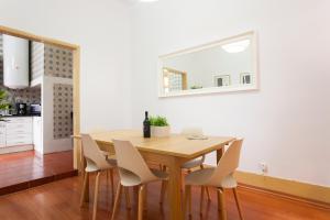 ein Esszimmer mit einem Holztisch und Stühlen in der Unterkunft Coliseu by Central Hill Apartments in Lissabon + 11 Fotos
