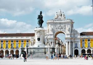 a statue in front of a building with people walking around it at Casa Portuguesa Ouro in Lisbon